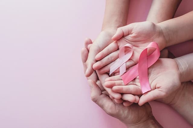 Mains tenant le ruban rose d'octobre rose lutte contre le cancer du sein
