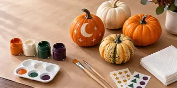 Une activité de décoration de citrouilles avec peintures et pinceaux