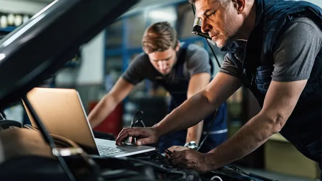 Des experts en train de contrôler sous le capot d'une voiture