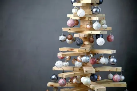 Un sapin fabriqué avec des planches de bois et décoré de boules