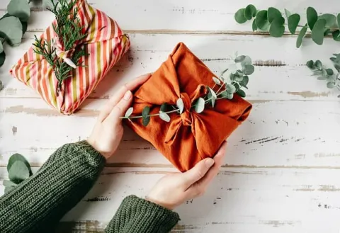 Un cadeaux emballé dans du tissu rouge